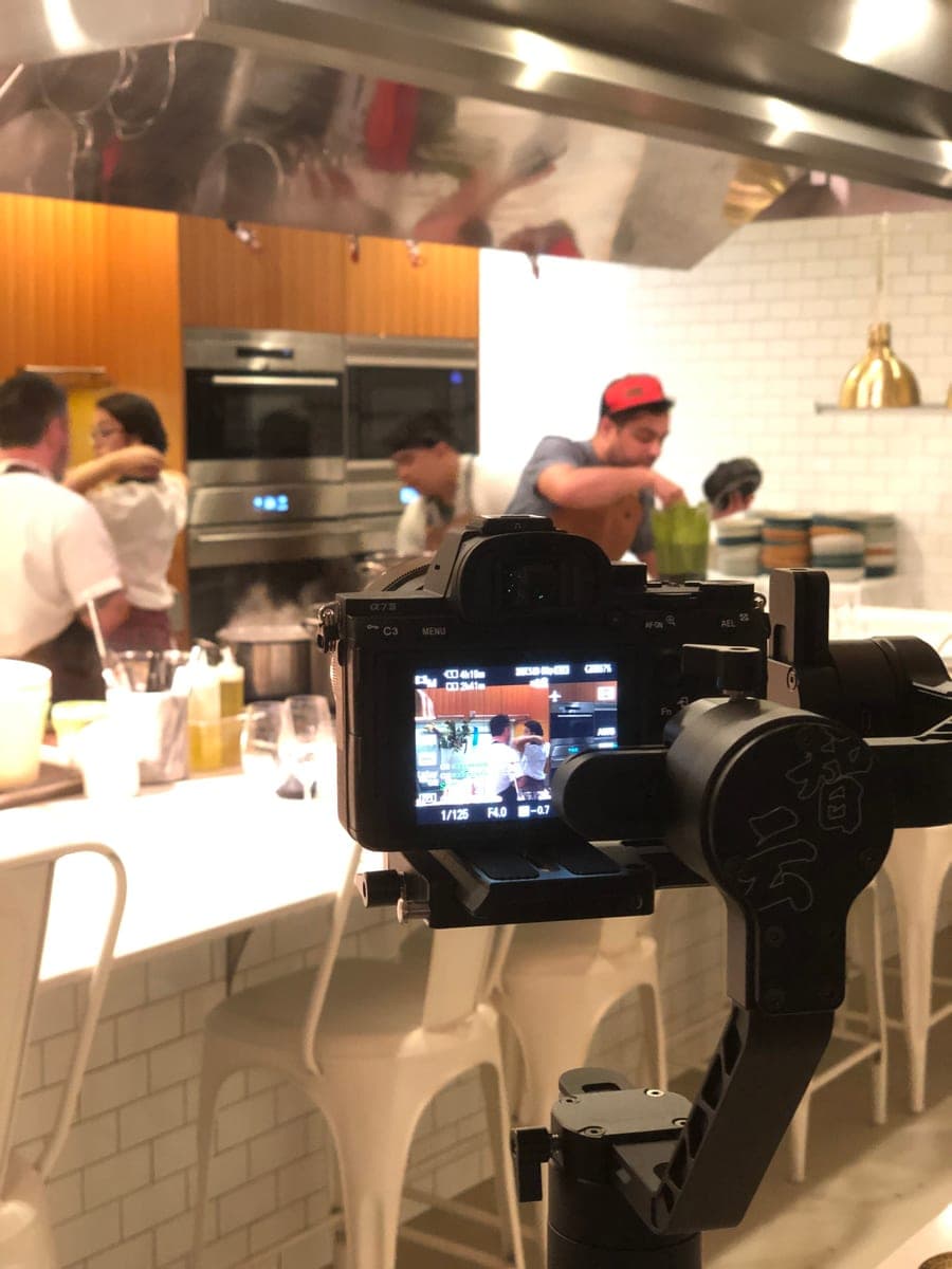 A camera on a gimbal filming service in an open restaurant kitchen