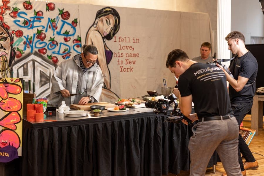 Chef Masaharu Morimoto plating while the MediaScher crew films