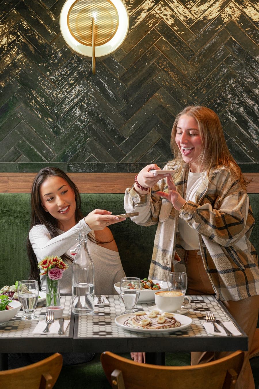 Two of the team photographing dishes on location at a restaurant
